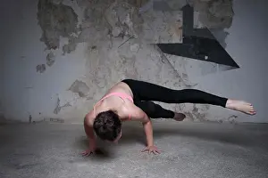 Agility Prints: Mid adult woman practicing parsva bakasana pose in yoga studio, Munich, Bavaria, Germany