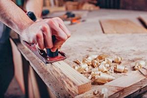 Work Tool Prints: Midsection of carpenter planing wood at workshop