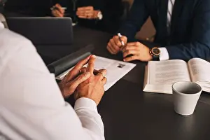 Organizing Prints: Midsection of lawyer with client in meeting at law office