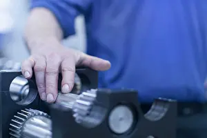 Manual Worker Prints: Midsection on mature engineer touching metallic spare parts