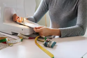 Skilled Prints: Midsection of teenage girl sewing textile at home