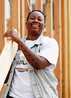Carpentry Prints: Mix race volunteer carrying lumber at construction site