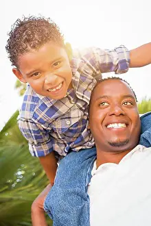 Assorted Prints: mixed-race son and african american father playing piggyback outdoors together