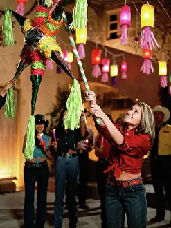 Gleeful Prints: Mixed race woman hitting pinata