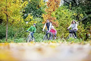 Dried Prints: MODEL RELEASED. Family cycling together in autumn