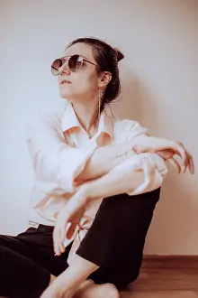 Pensive Prints: Modern woman in minimalist style sitting indoors
