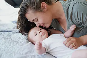 Maternity Prints: Mom, baby and smile on bed in home for support