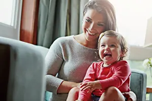Mom, toddler and happy with laughing on sofa in home living room with care