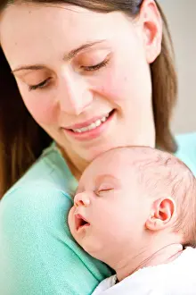 Brown Haired Prints: One month old baby sleeping in mother's arms