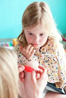 Injury Prints: Mother applying band-aid on wounded knee of a girl