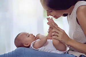 Kiss Prints: Mother, baby and playing with feet in home for bonding