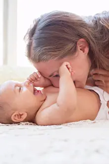 Bare Chest Prints: Mother blowing raspberries on baby's stomach, London, UK