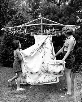 Bedding Prints: Mother and daughter hanging laundry in backyard