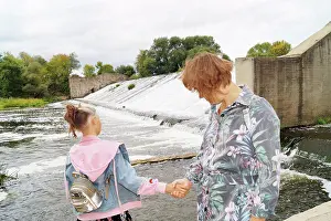 Denim Prints: Mother and daughter hold hands on the dam