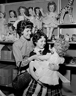 Consumerism Prints: Mother and daughter observing doll in toy shop