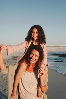 Quality Time Prints: Mother giving daughter piggyback ride on beach