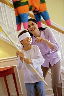 Mixed Prints: Mother helping her daughter hit a pinata
