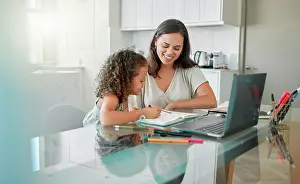 Mother helping her girl with writing her homework of a happy family house in her creative kids notebook