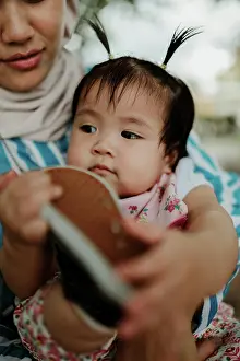 Grandfather Prints: Mother holding baby girl in the park