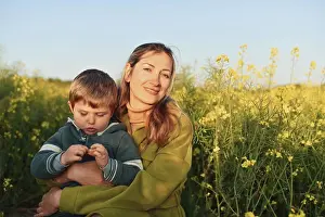 Normandy Prints: Mother and son in a rapeseed field in spring