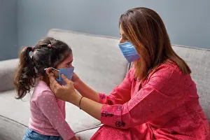 Precaution Prints: A MOTHER WEARING MASK HELPING DAUGHTER TO WEAR MASK FOR SAFETY