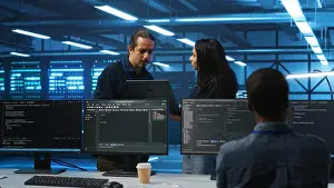 Electronics Prints: Multiethnic team of admins working in high tech server room capable of storing vast amounts of data