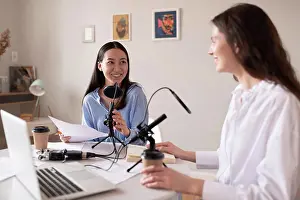 Asian And Indian Ethnicities Prints: Multiracial women recording podcast in studio