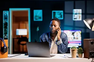 Home Office Prints: Multitasking professional efficiently manages a conversation on her mobile device while simultaneously working