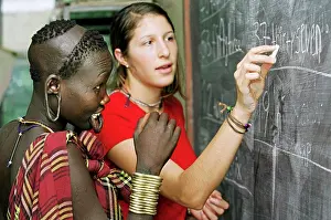 Focus On Foreground Prints: Mursi tribal girl with ear lobes and lower lip pierced during English lesson ran by Christian missionaries