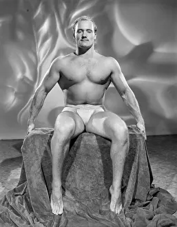 Attractive Prints: Muscular Bodybuilder Seated with Hands Outside c.1952