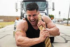 Heavy Prints: Muscular Hispanic man wearing tank top with Strong tattoo on his bicep