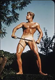 Bodybuilder Prints: Muscular Male Holds Sword in Mountain Setting c.1950