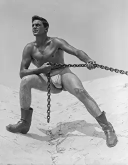 Nude Prints: muscular nude in boots pulling chain on mountain c.1951