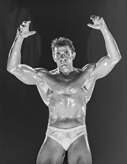 Bodybuilder Prints: Muscular Oiled Male Poses with Arms Raised c.1950