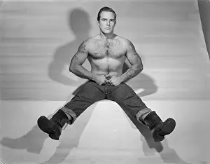 Bodybuilder Prints: Muscular Tattooed Bodybuilder Seated in Jeans and boots c.1952