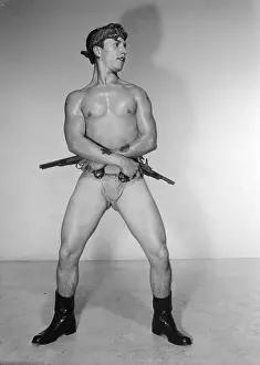 Attractive Prints: Muscular Tattooed Nude with Two Guns and Boots c.1962