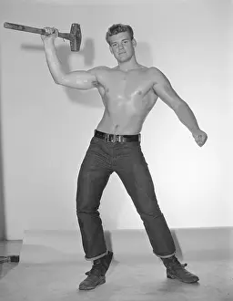 Bodybuilder Prints: Muscular Young Man Holding Sledgehammer c.1962