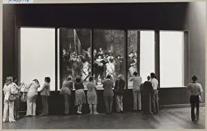 Restored Prints: Nachtwacht achter een scheidingswand met vensters waar publiek doorheen kijkt