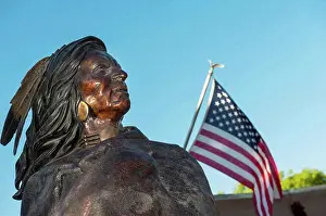 Arts Culture And Entertainment Prints: Native American Indian Bronze Statue Next To An American Flag At Friday Night Canyon Road Gallery Walk In Santa Fe
