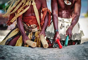 Fiji Prints: Two native Fijian men in traditional dress beating log ithe sticks making music