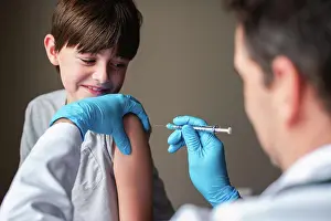 Tooth Prints: Nervous looking child getting vaccinated by doctor holding a needle