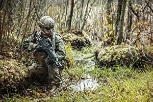 Swamp Prints: Norwegian Rapid reaction special forces FSK soldier kneeling in the swamp