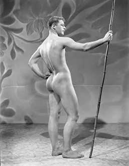 Attractive Prints: nude male stands in vibrant studio holding staff c.1954