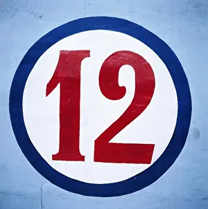 Numbers Prints: Numeric twelve written in circle on blue wall