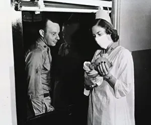 Archives Prints: A nurse holds a newborn baby up to the window of a hospital ward