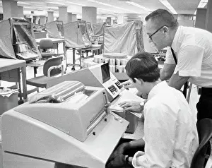 Place Of Work Prints: Office worker demonstrates the computer interrogation device for updating customer records