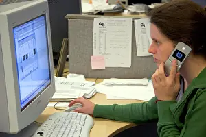 Electronics Prints: Office worker using a computer and cell phone. MR