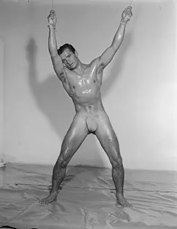 Bodybuilder Prints: Oiled Muscular Bodybuilder Hangs Nude from Ceiling c1962