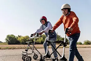 Best Prints: Two old friends wearing safety helmets, competing in a wheeled walker race