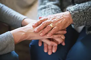 Old person, friend and holding hands for comfort on sofa for grief loss or support